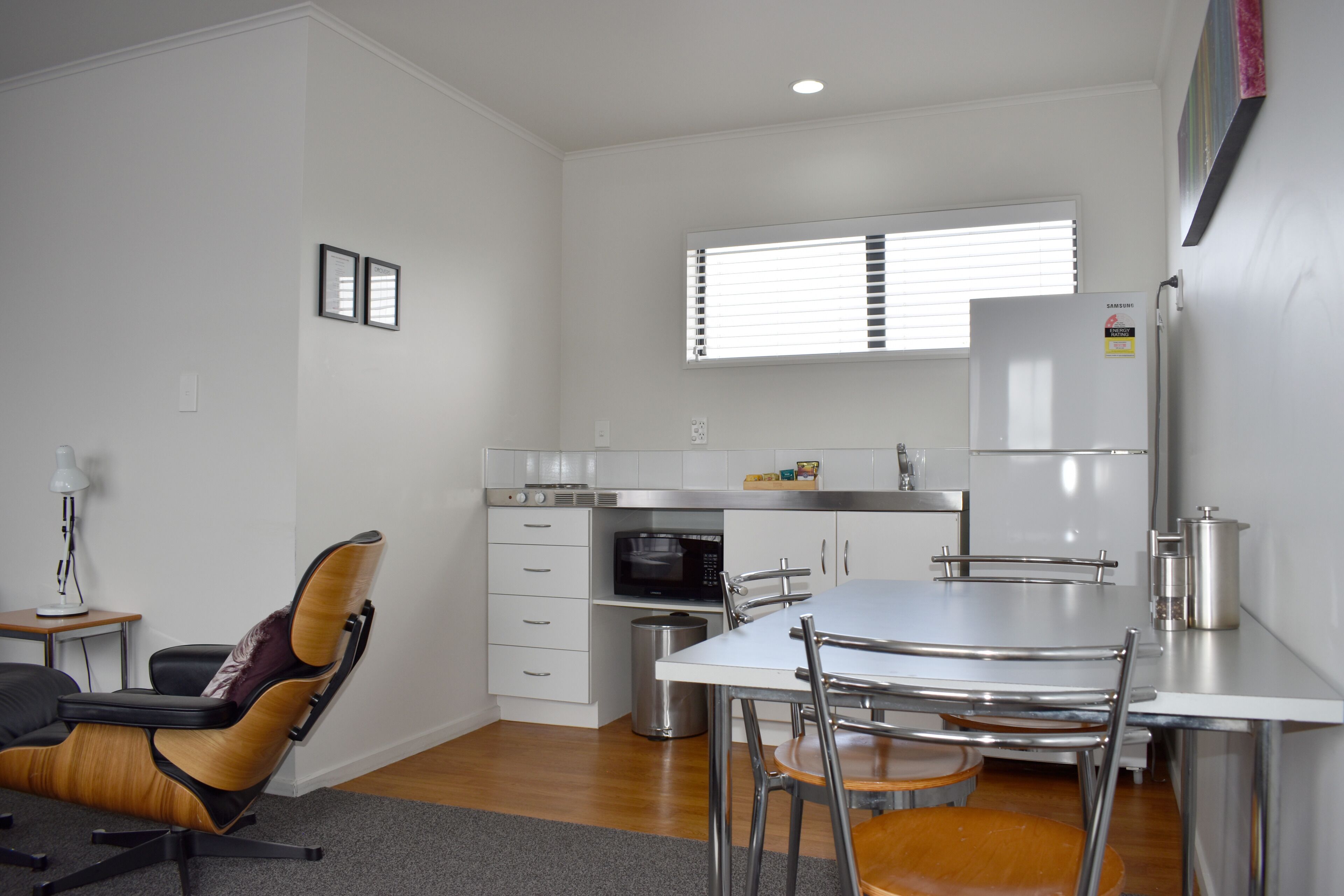 A compact kitchen with a dining area, a microwave, and a refrigerator.