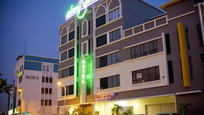 A hotel with a neon sign, multiple floors, and a visible address sign. - Alami Garden Hotel (Shah Alam)