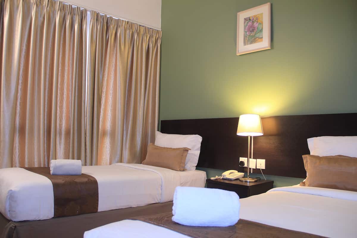 A hotel room with two beds, a nightstand, a lamp, and a painting on the wall.