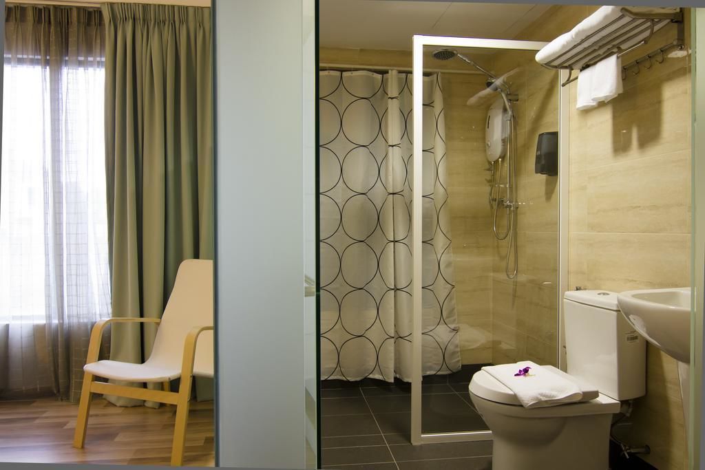 A modern bathroom with a shower, toilet, and sink.