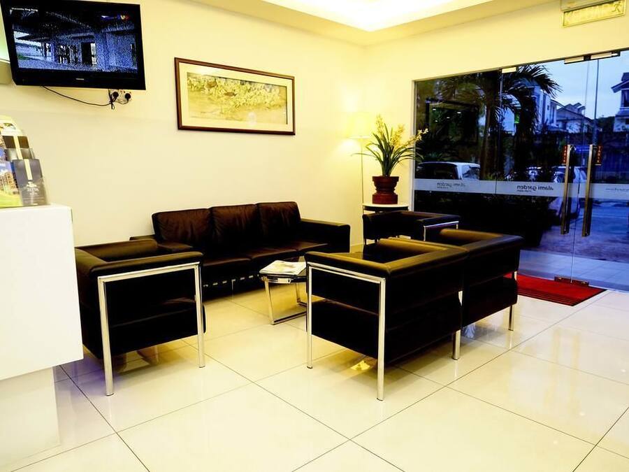A modern reception area with a sofa set, a TV mounted on the wall, and a framed picture.