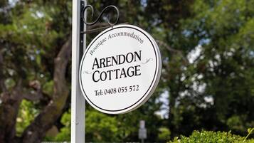 Welcome to Arendon Cottage, a serene retreat surrounded by lush greenery.