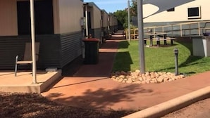 A row of modern, single-story mobile homes with a covered walkway between them. - Karratha Lodge (Karratha Industrial Estate)