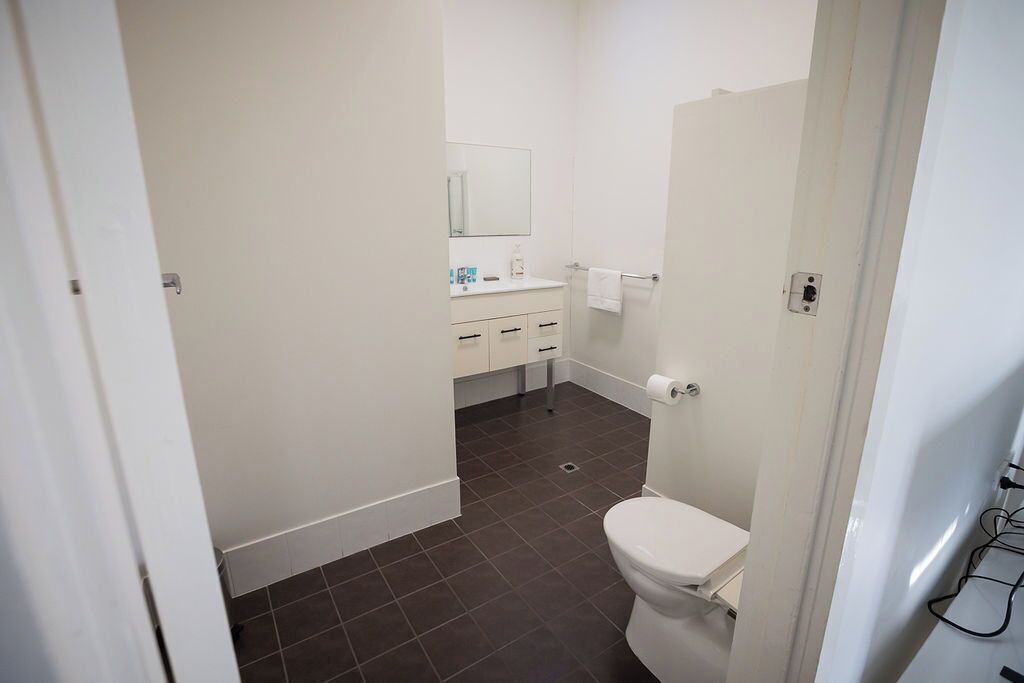 Un baño con inodoro, lavamanos y espejo.