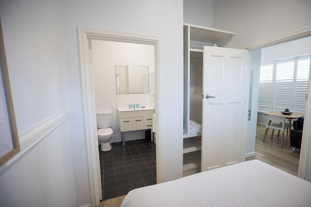 A bedroom with a bed, a bathroom with a toilet and sink, and a closet.