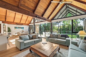 Un amplio salón con techo alto, ventanas grandes y una chimenea moderna.