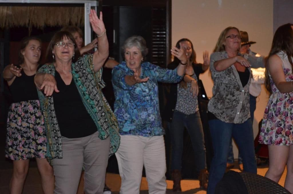 A group of people engaged in an activity, possibly a dance or exercise, indoors.