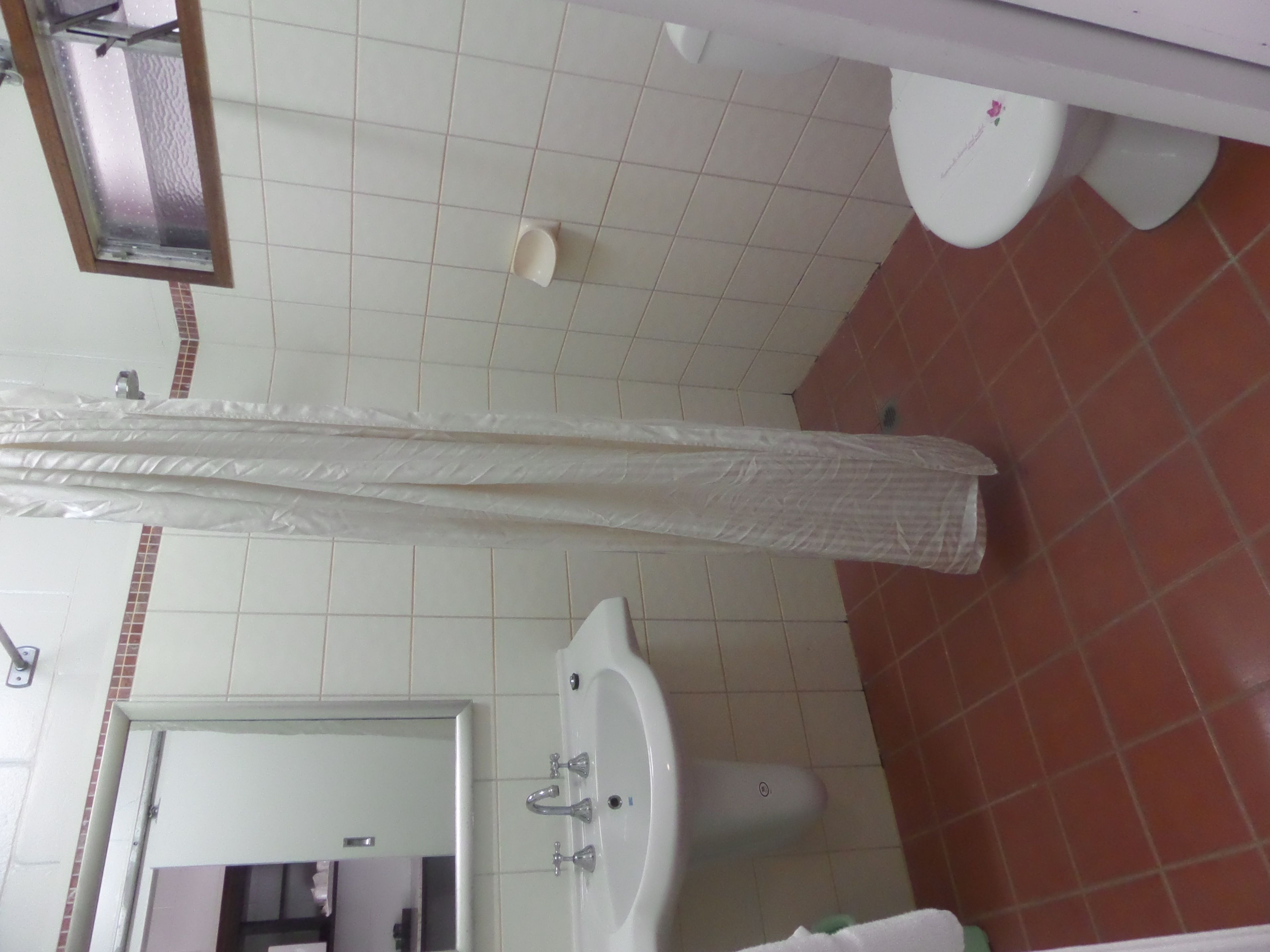 Un baño con lavamanos, espejo e inodoro.