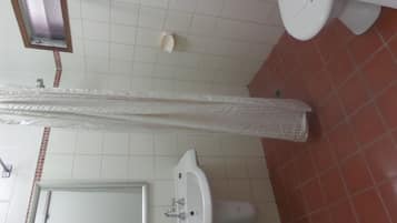 Une salle de bain avec un lavabo, un miroir et des toilettes.