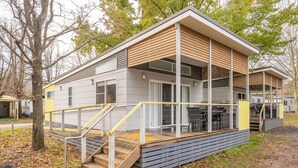 A modern building with a flat roof, large windows, and a covered outdoor area with steps leading up to it. - NRMA Bright Holiday Park (Bright)