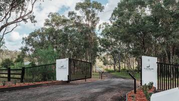 A gated entrance to a property with a sign indicating 'Clayfields Hunter Valley Artisan Honey.'