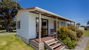 A single-story house with a front porch, a small deck, and a front door. - Wellington TOP 10 Holiday Park (Lower Hutt)