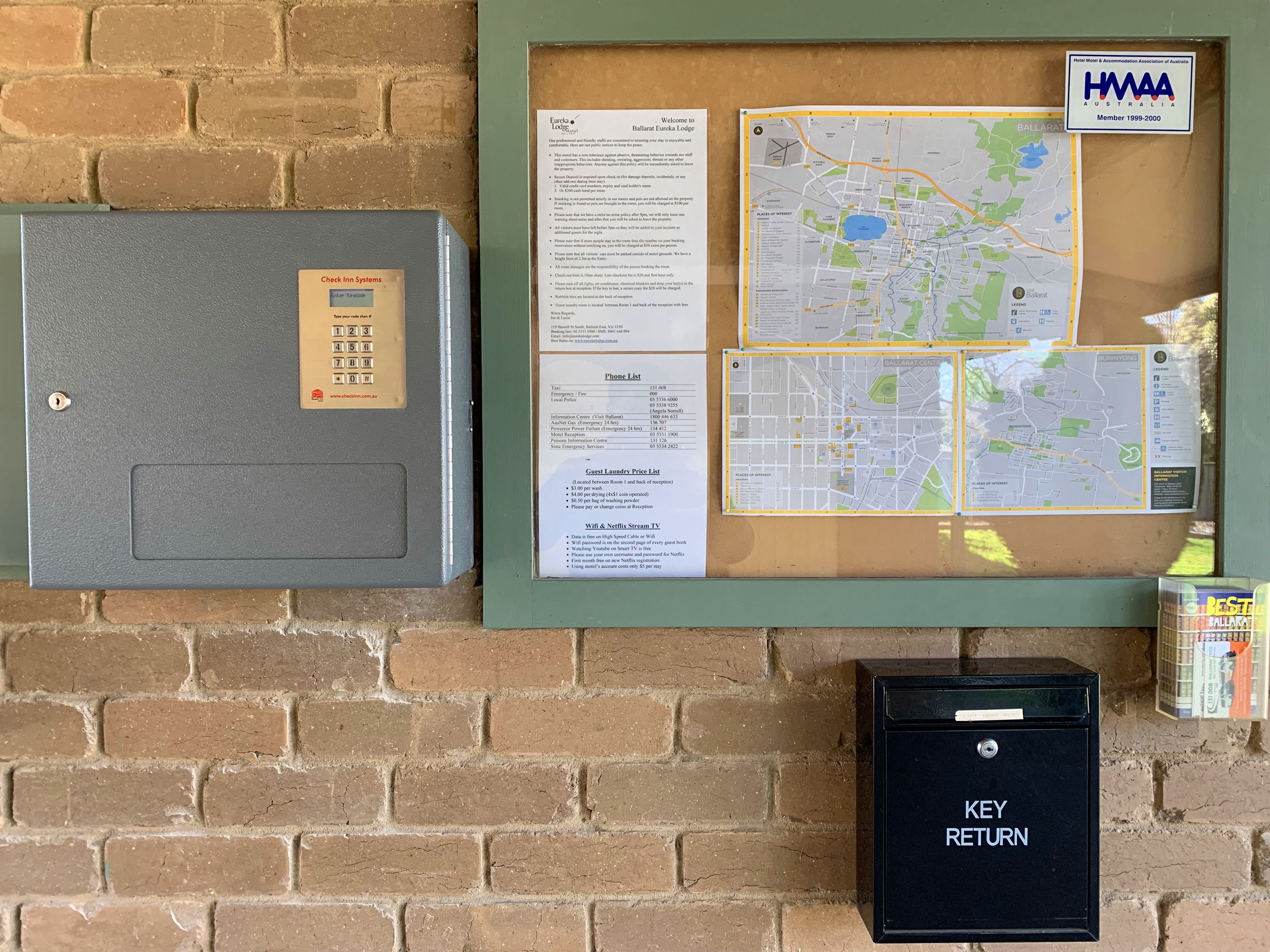A bulletin board with a map, a phone list, and a key return box.