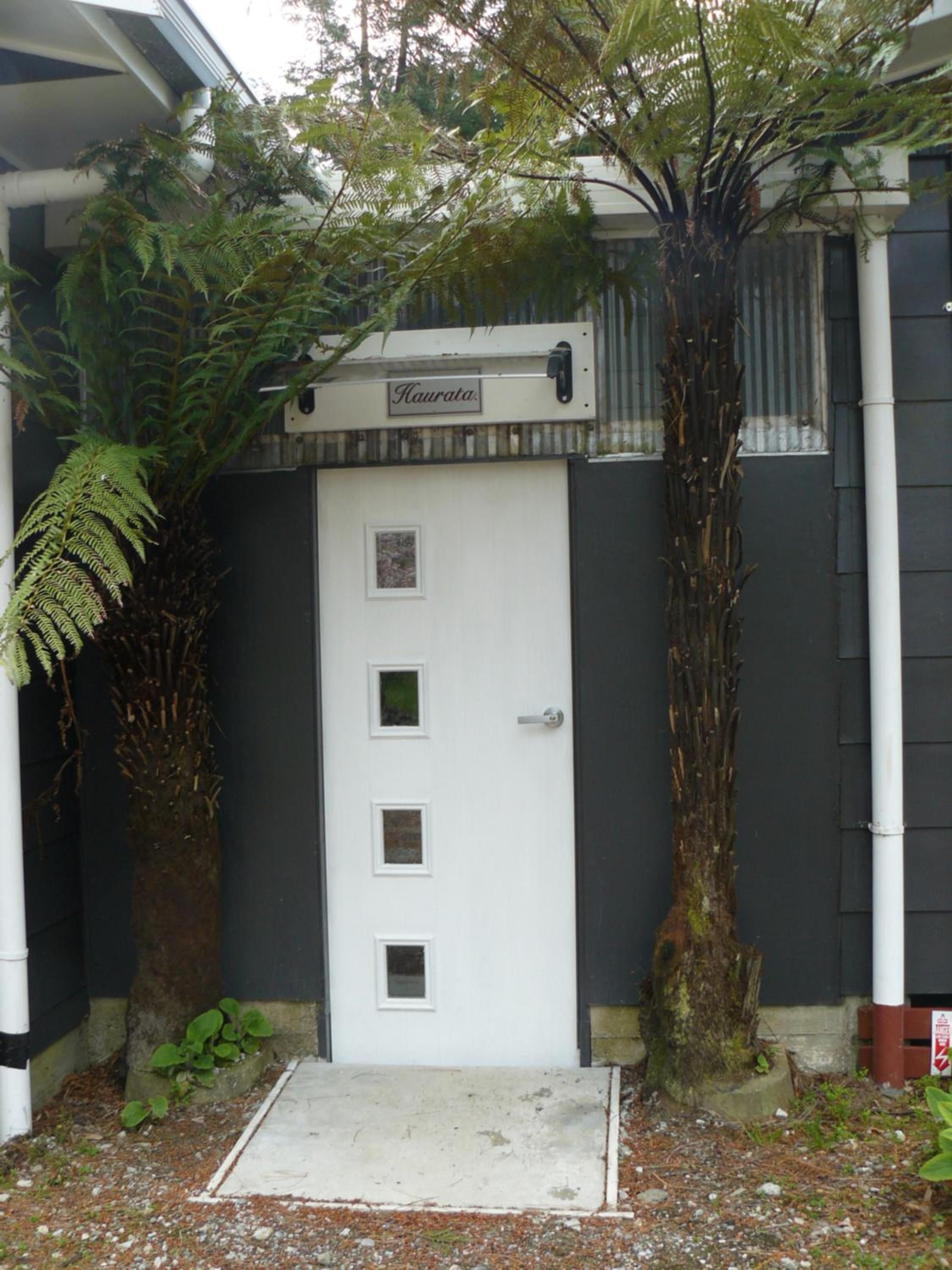 A white door with a small window and a sign above it.