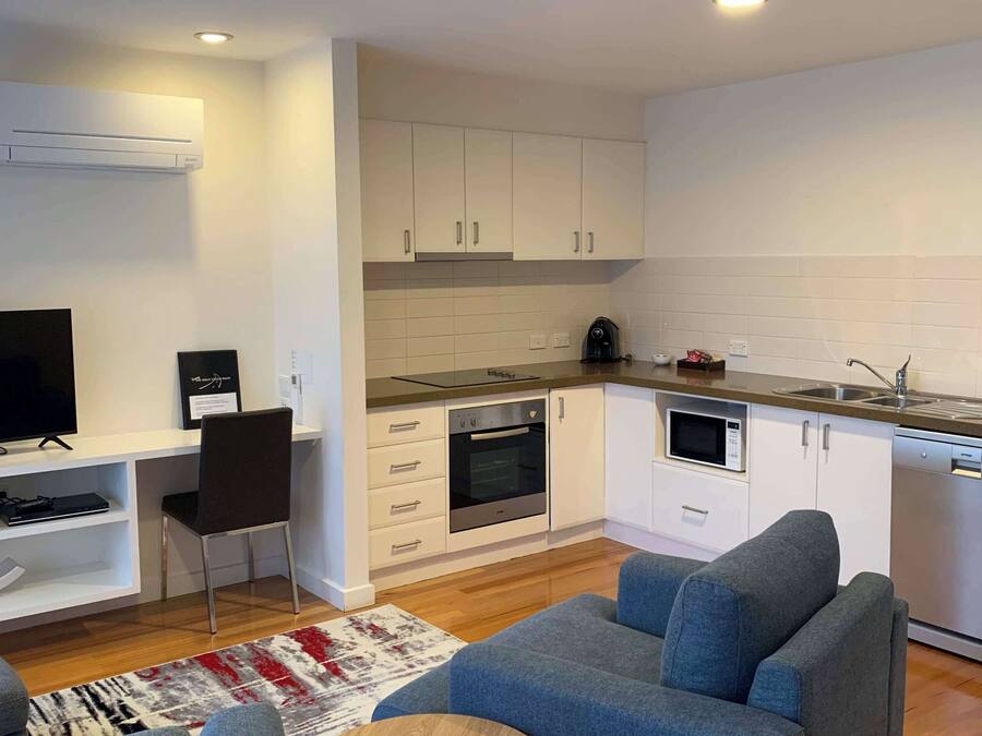 A modern apartment with a living room, kitchen, and a small dining area.