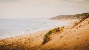 Una playa con arena y olas suaves.