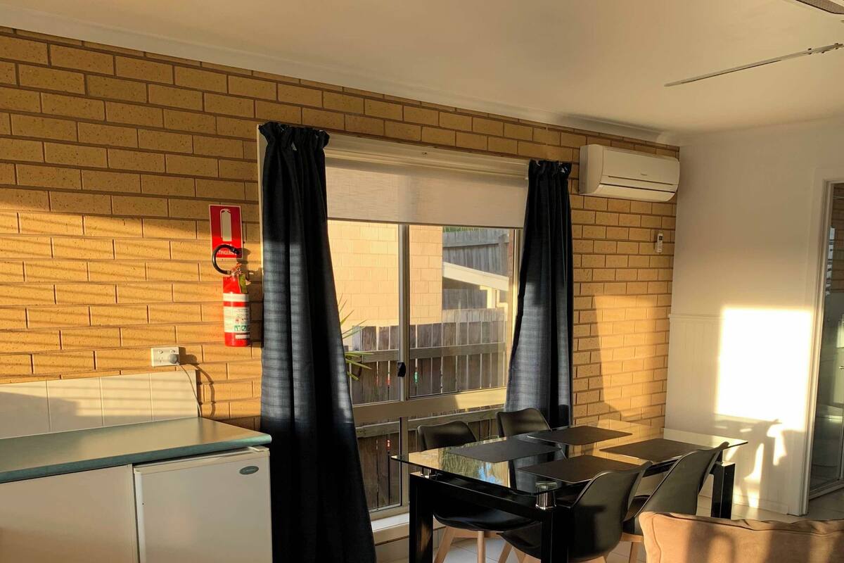 A compact living space with a kitchenette, a dining area, and a sofa.
