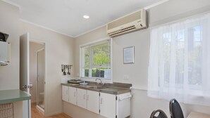 Eine moderne Küche mit Einbauofen, Spüle und einem Fenster mit Jalousien.