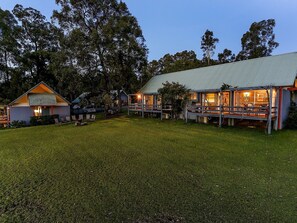 A campground with multiple cabins, a grassy area, and trees in the background. - Vineyard Hill (Lovedale)