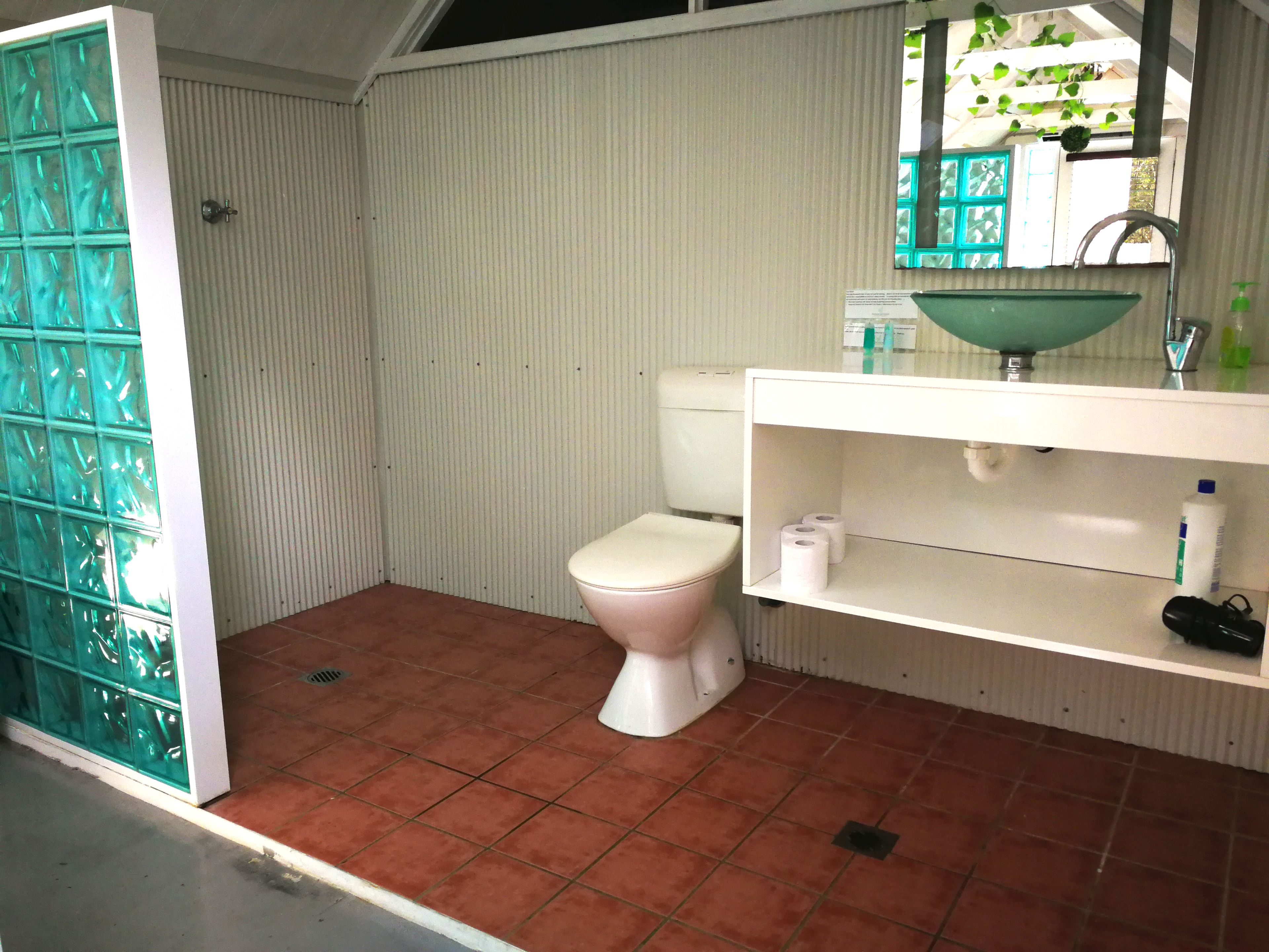 A small bathroom with a toilet, a sink, and a mirror.