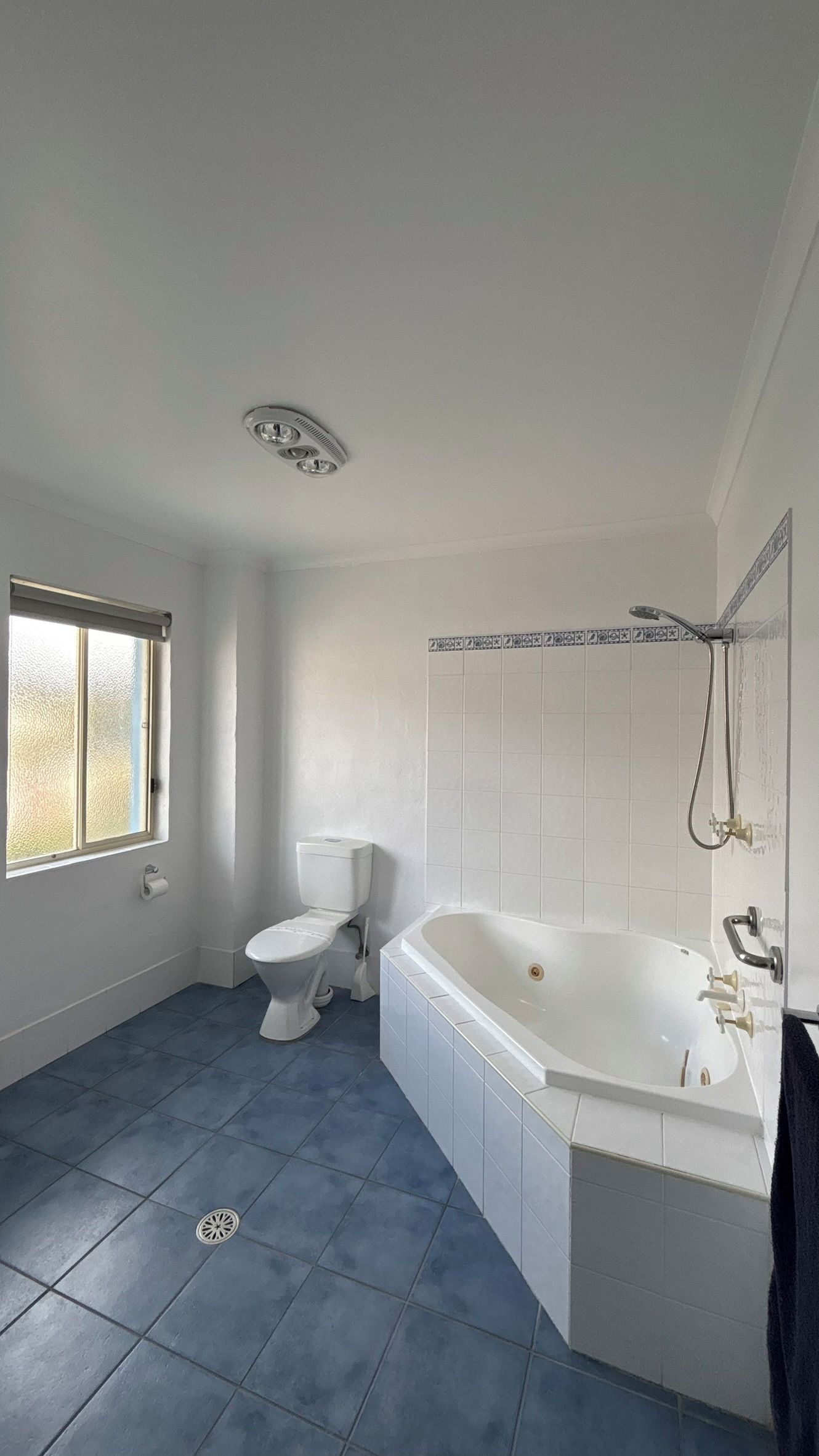 Een badkamer met toilet, bad en raam.