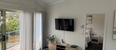Ett modernt vardagsrum med en soffa, ett soffbord, en tv och en takfläkt.