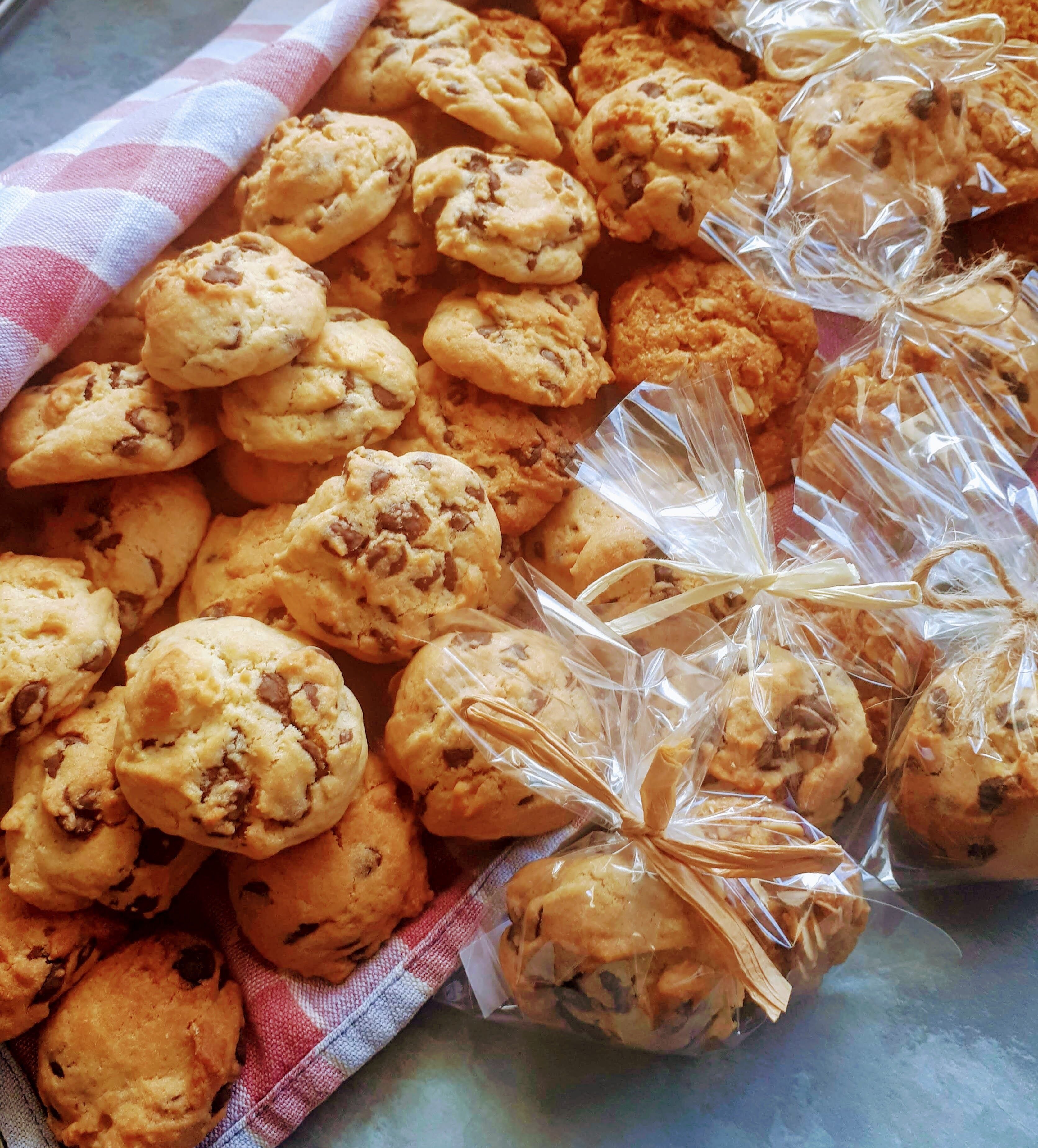 Een dienblad met koekjes, waarvan sommige in plastic verpakt en vastgebonden met een lint.