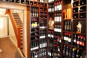 A wine cellar with wooden shelves and a staircase. - Nice Hotel (New Plymouth)