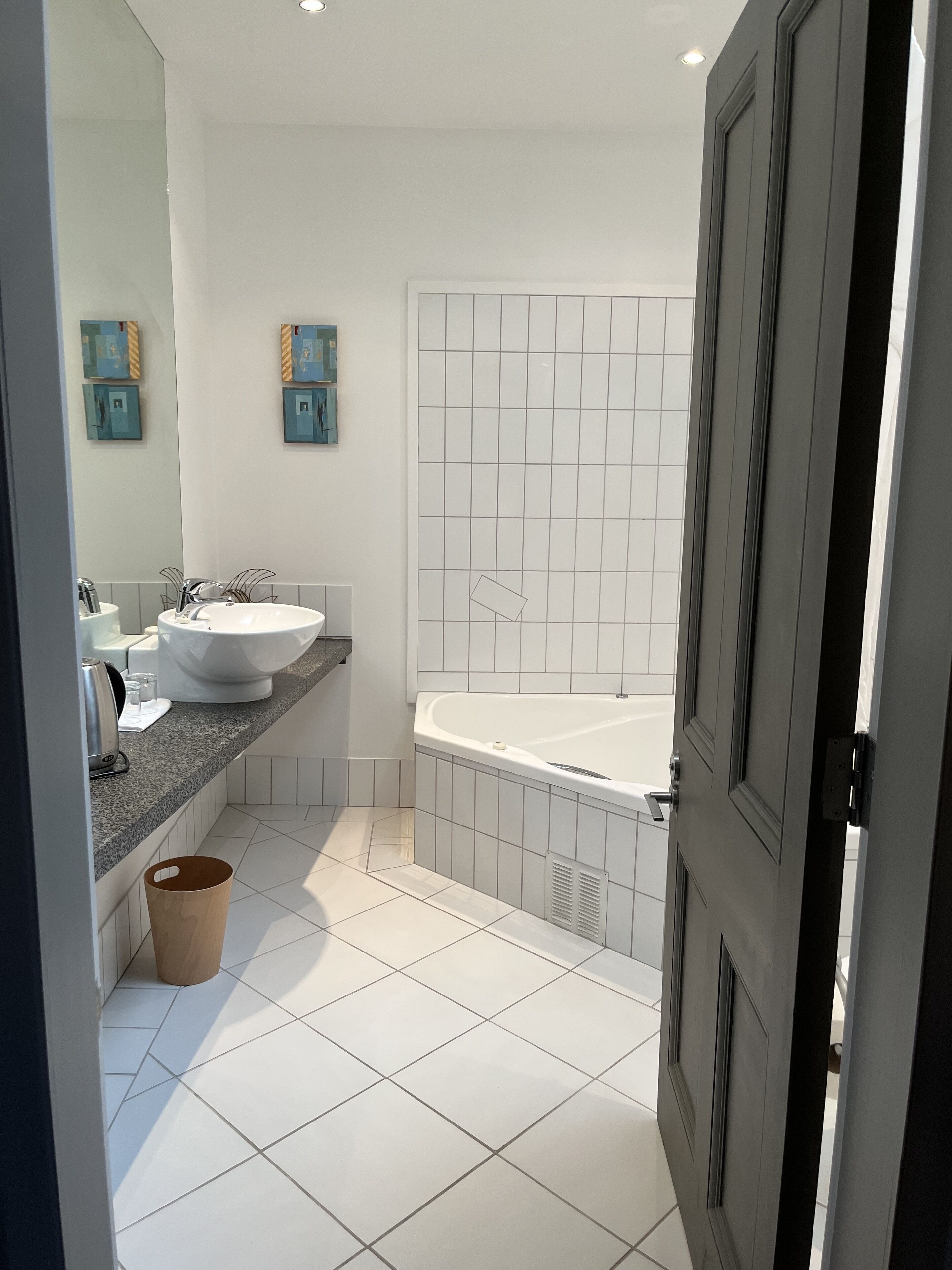 A modern bathroom with a large bathtub, a sink, and a vanity.