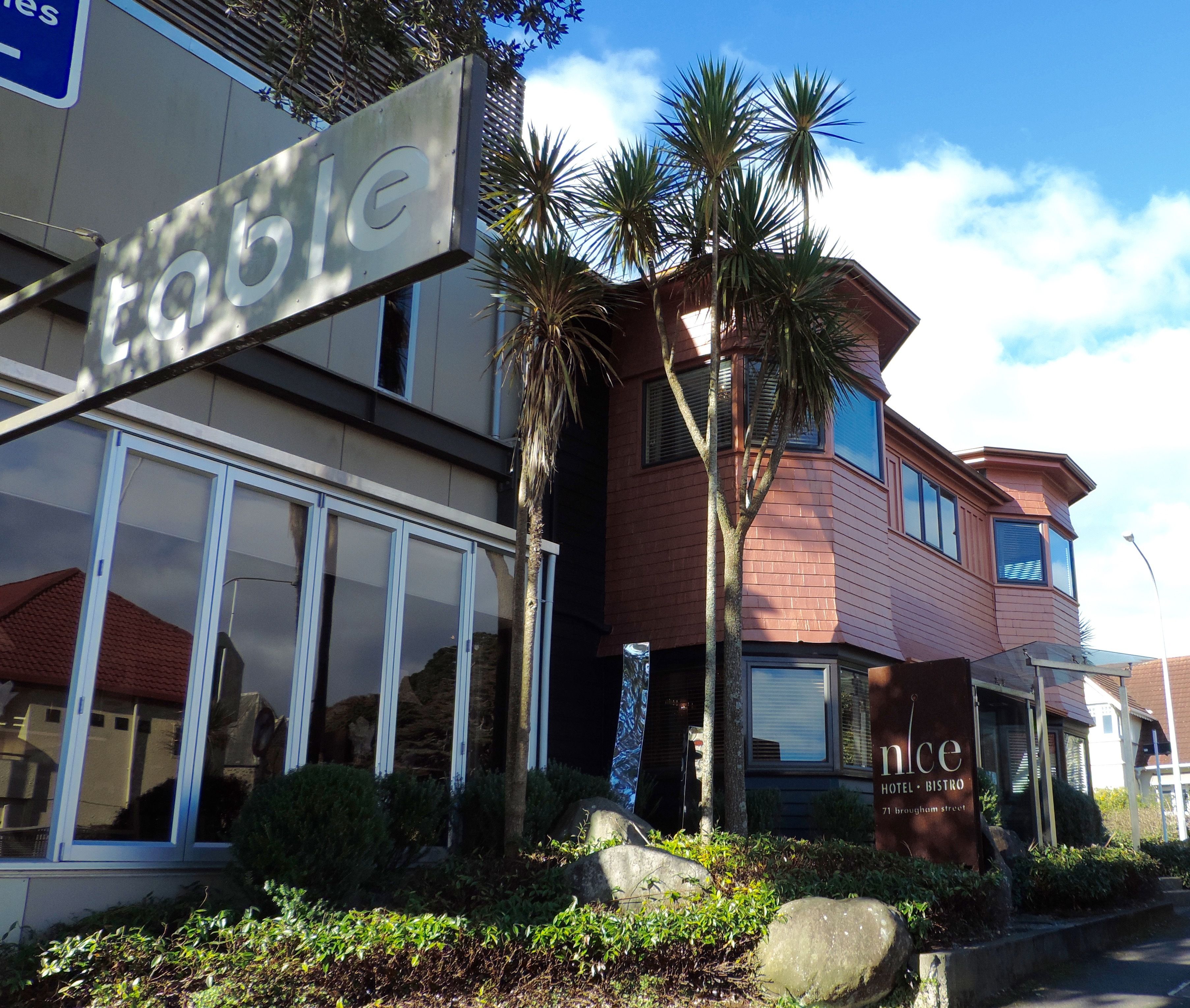 A hotel with a modern design, featuring large windows and a mix of brick and stucco exterior.