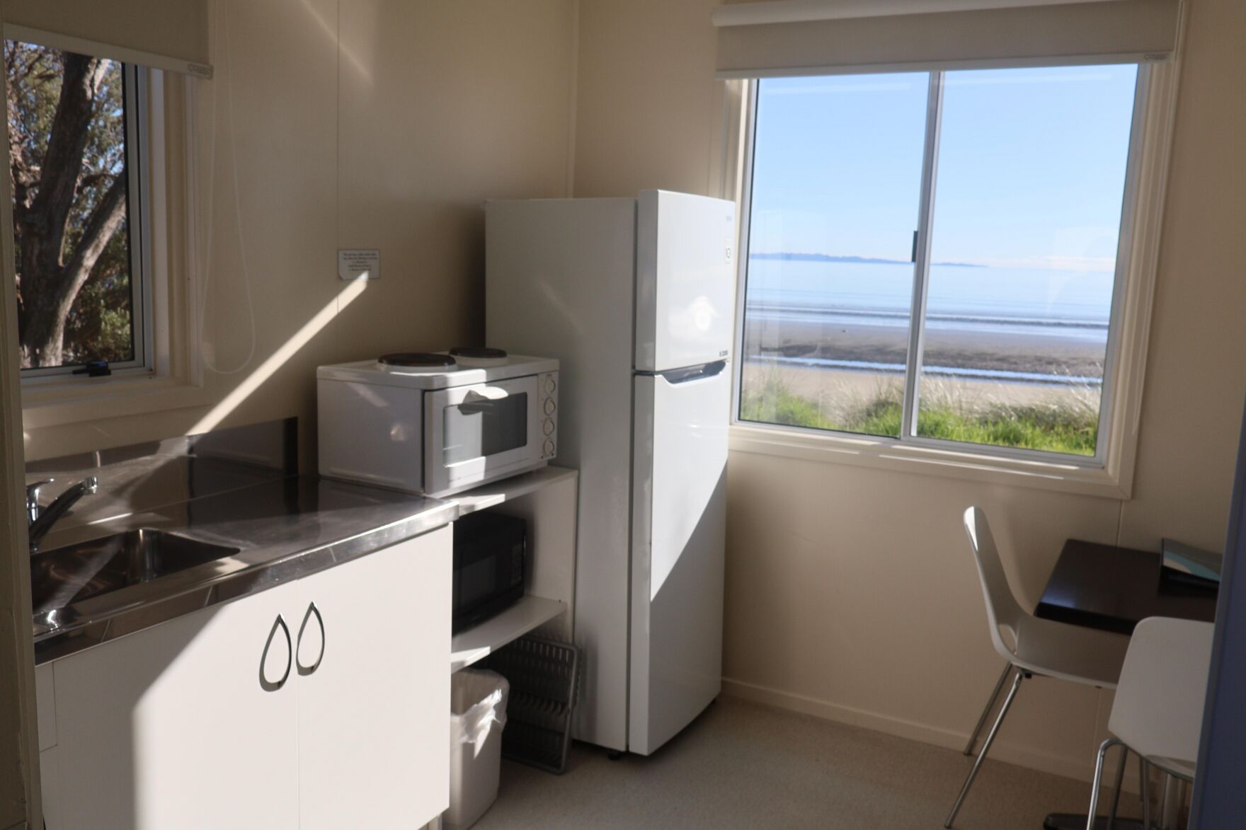 Une cuisine compacte équipée d’un four à micro-ondes, d’un réfrigérateur et d’un évier.