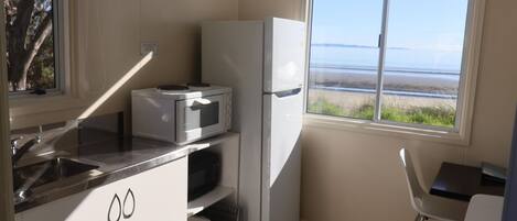 Une cuisine compacte équipée d’un four à micro-ondes, d’un réfrigérateur et d’un évier.