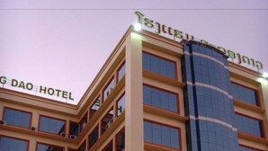 Een hotel met meerdere verdiepingen en een modern gevelontwerp, met een groot glazen gedeelte en diverse balkons.