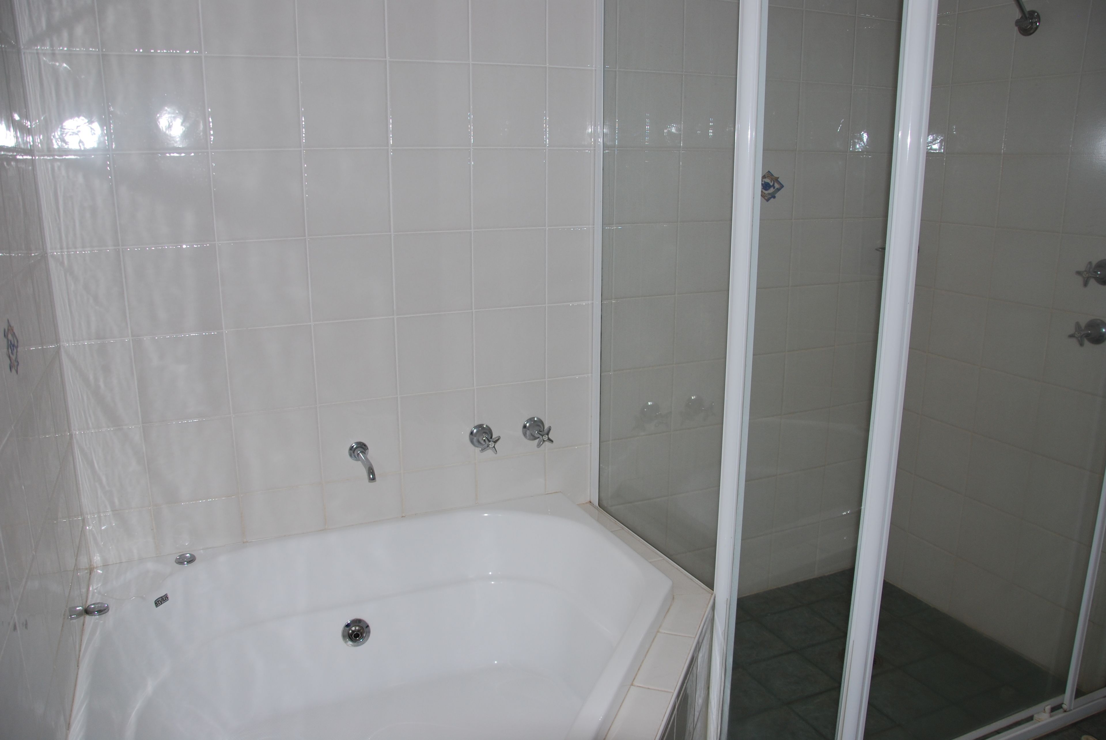 A bathroom with a bathtub, a shower, and tiled walls.