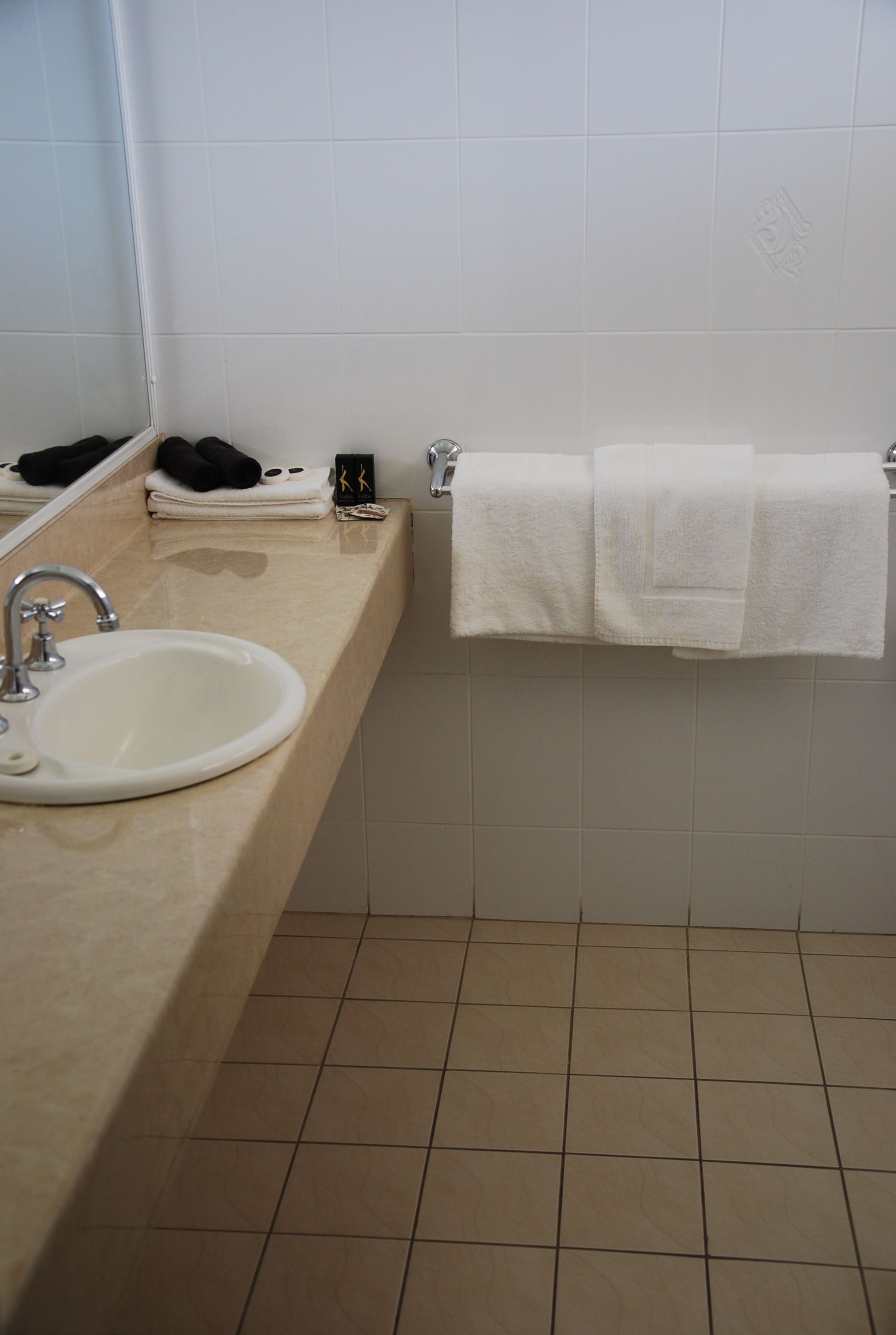 Ein Badezimmer mit Waschbecken, Spiegel und Handtuchhalter.