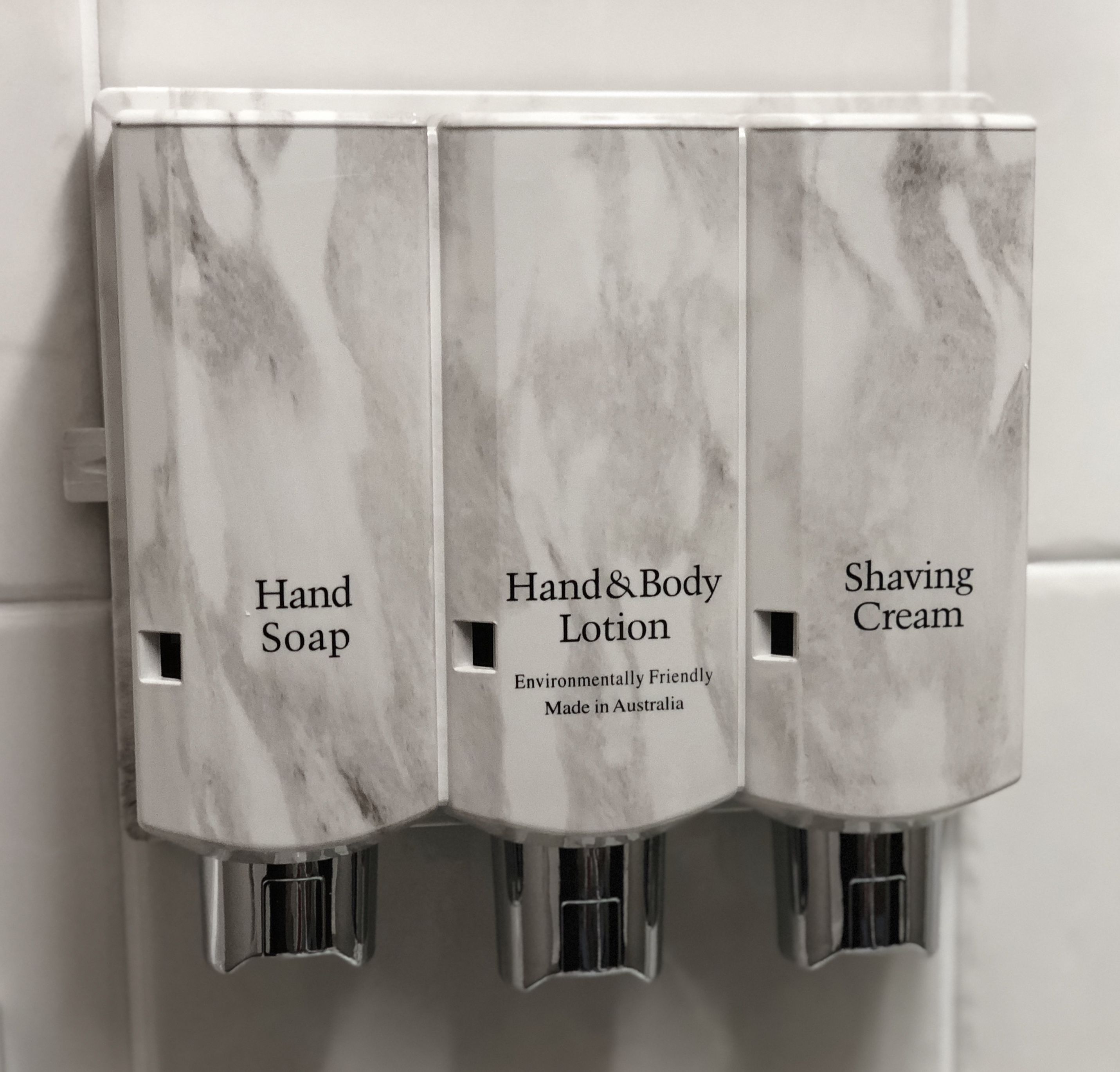 Dispensadores de jabón de manos, loción corporal y crema de afeitar en un baño.
