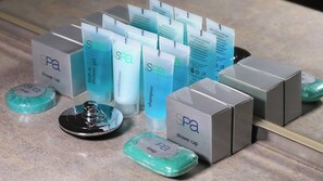 A variety of spa products including shower caps, soap, shampoo, and conditioner, arranged on a countertop.
