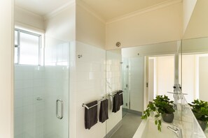 Executive appartement | Badkamer | Een douche, een haardroger, pantoffels, handdoeken