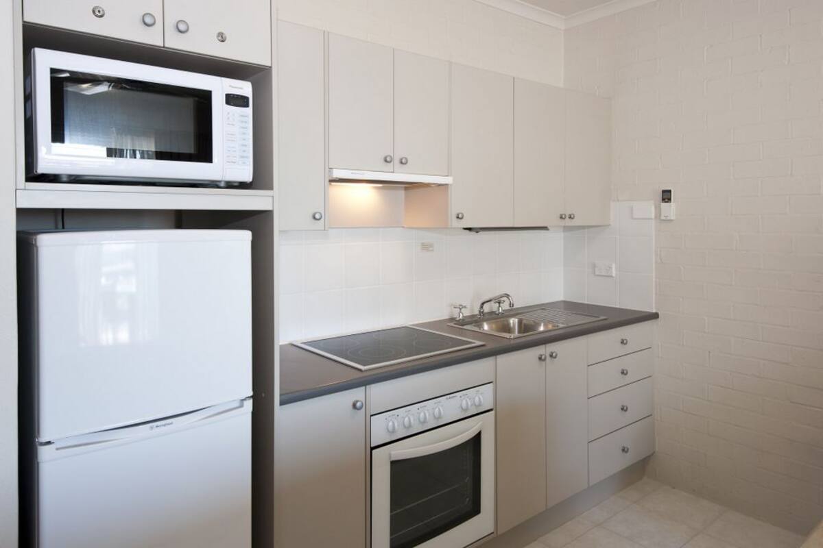 A modern kitchen with a microwave, refrigerator, stove, and sink.