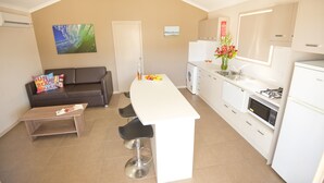 Una cocina compacta con una isla central, un sofá y un comedor.