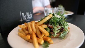 Un plato con un sándwich y papas fritas sobre una mesa, con un letrero que dice "The Black".