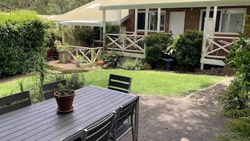 Relax on the patio with a meal or a moment of peace, surrounded by lush greenery and a tranquil landscape.