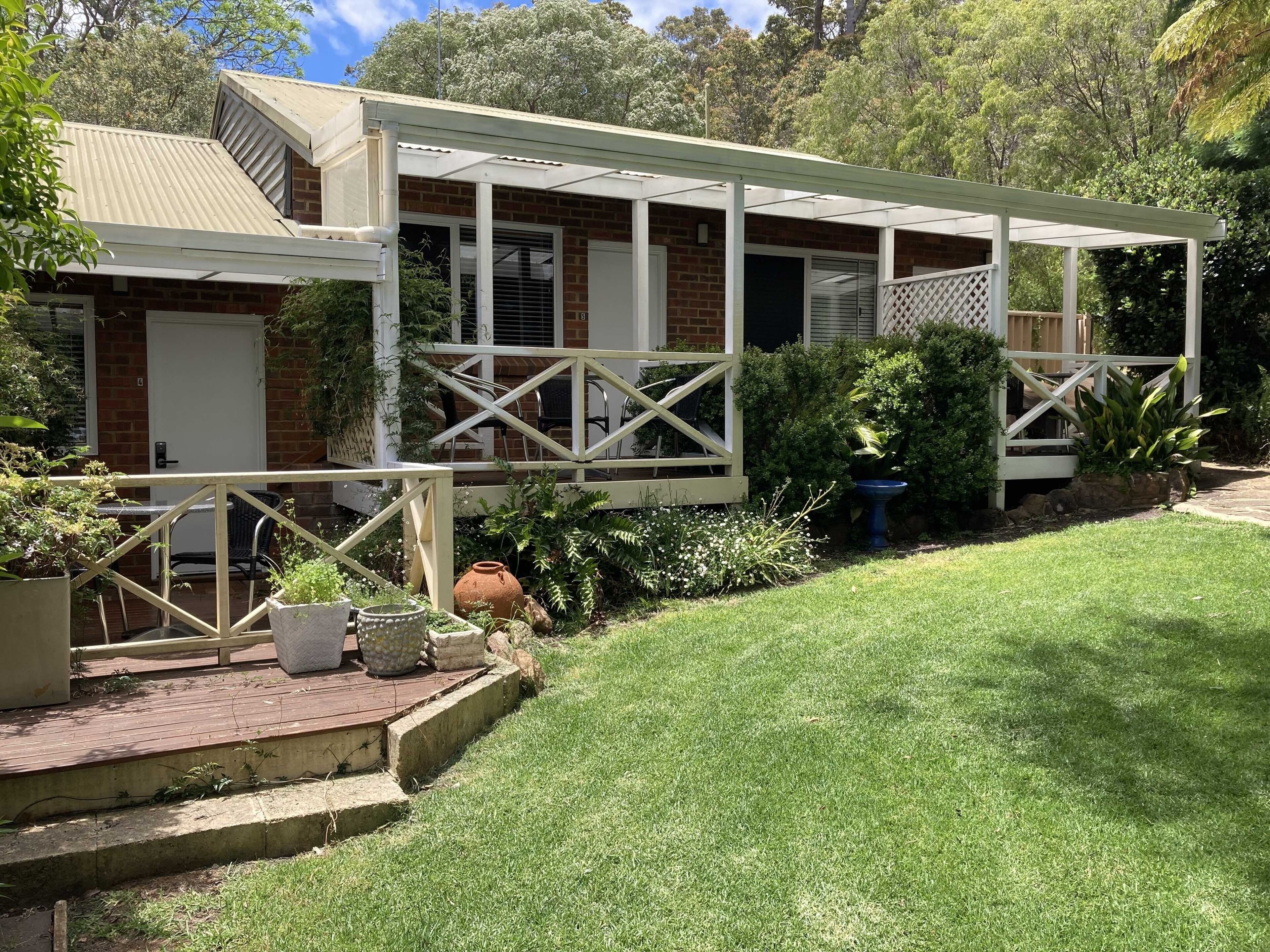 A house with a covered porch, brick walls, and a well-maintained garden.