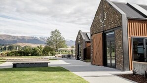 A modern building with a sloped roof, large windows, and a stone facade. - Harvest Hotel (Cromwell)