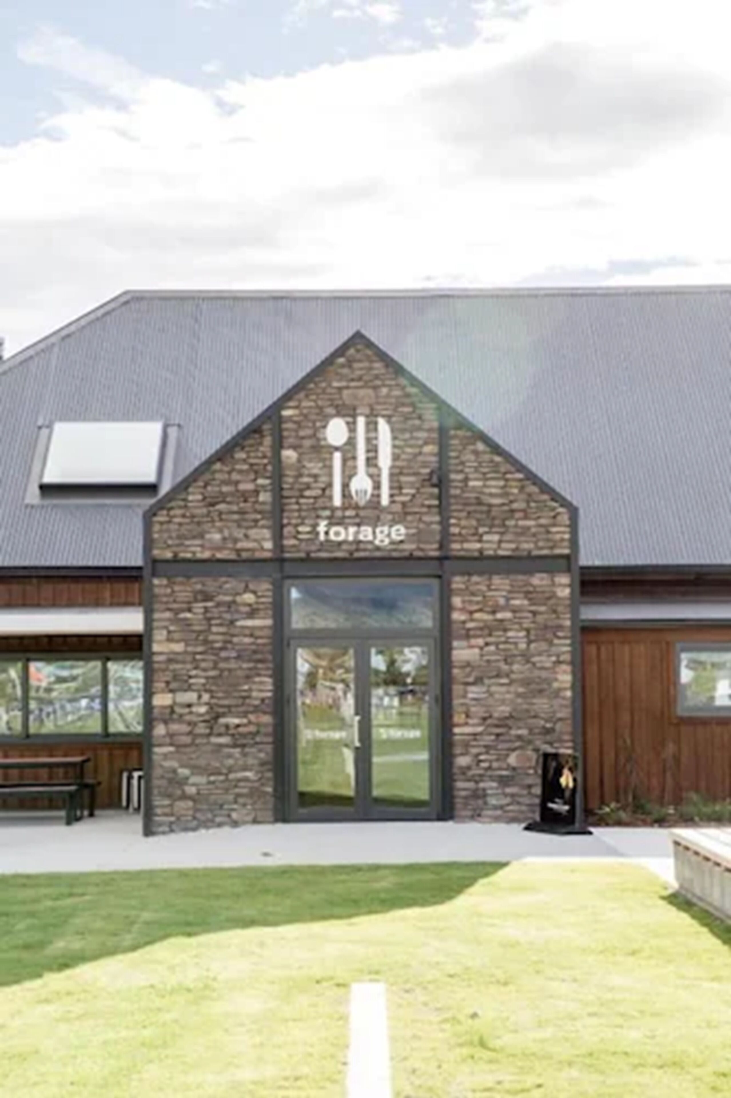 A building with a stone facade and a sign that reads "forage."