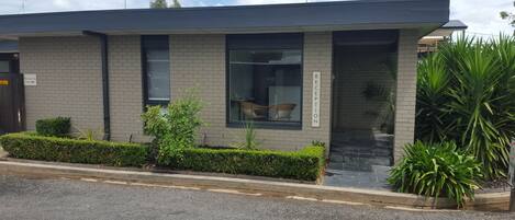 A modern building with a reception area, a large window, and a sign indicating a reception.