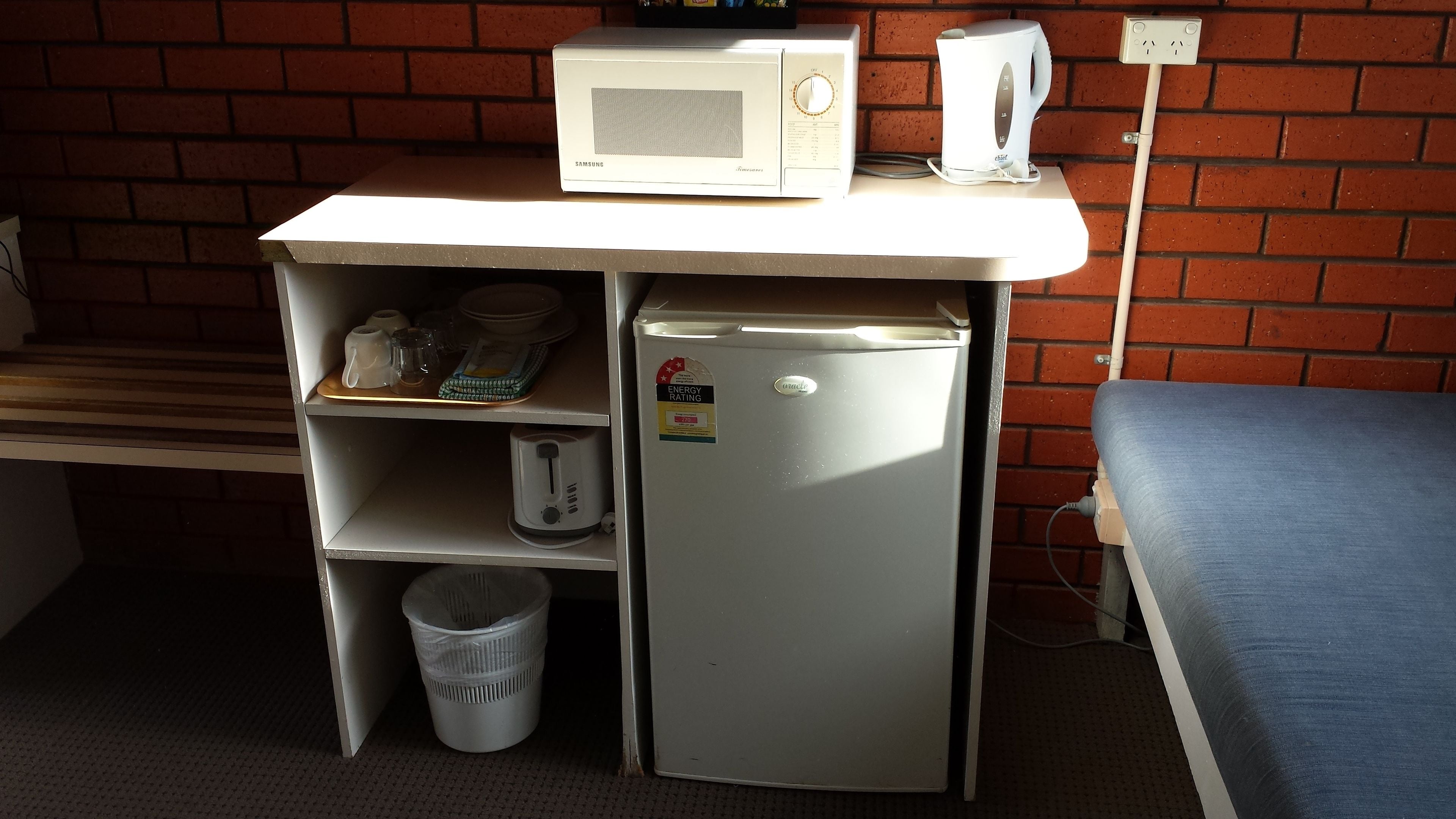 A compact kitchenette with a microwave, toaster, and small refrigerator.