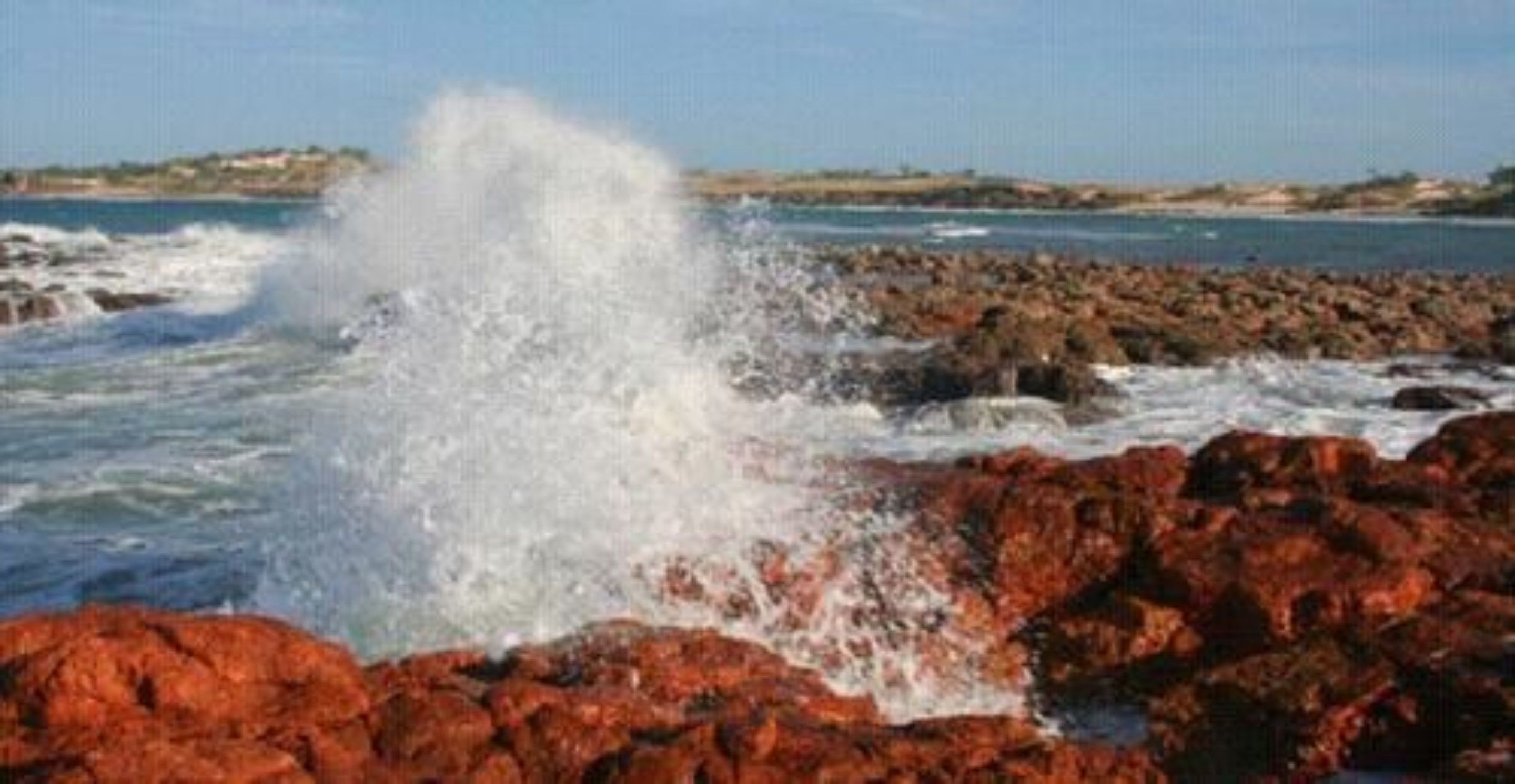 A rocky shoreline with waves crashing against the rocks.