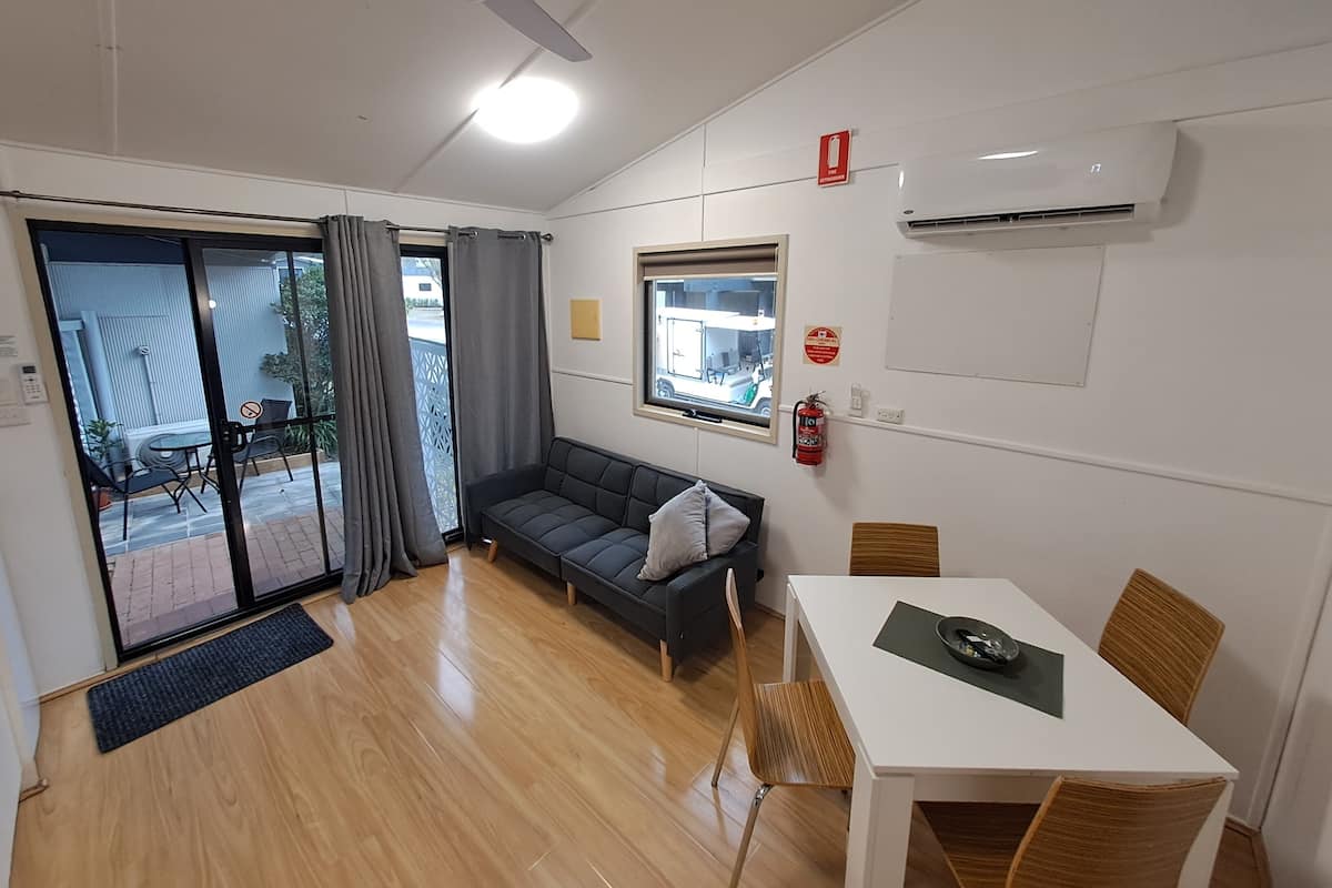 Un salon moderne avec un canapé, une table à manger et un ventilateur de plafond.