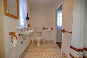 A bathroom with a sink, toilet, and mirror. - Rosedale Cottages (Taranna)